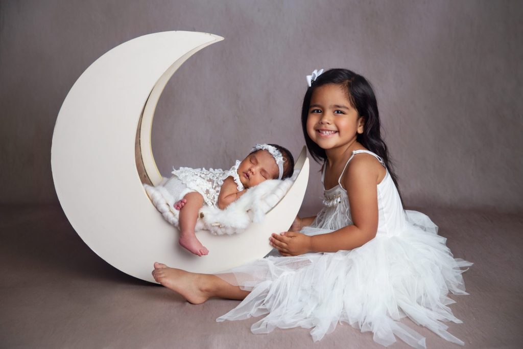 posed sibling and newborn photography with moon prop in scotch plains new jersey