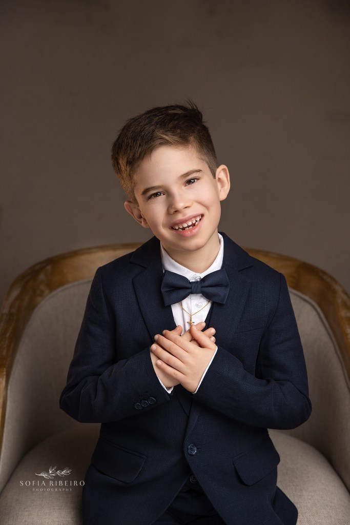 a smiling portrait of a young child getting his first communion portraits