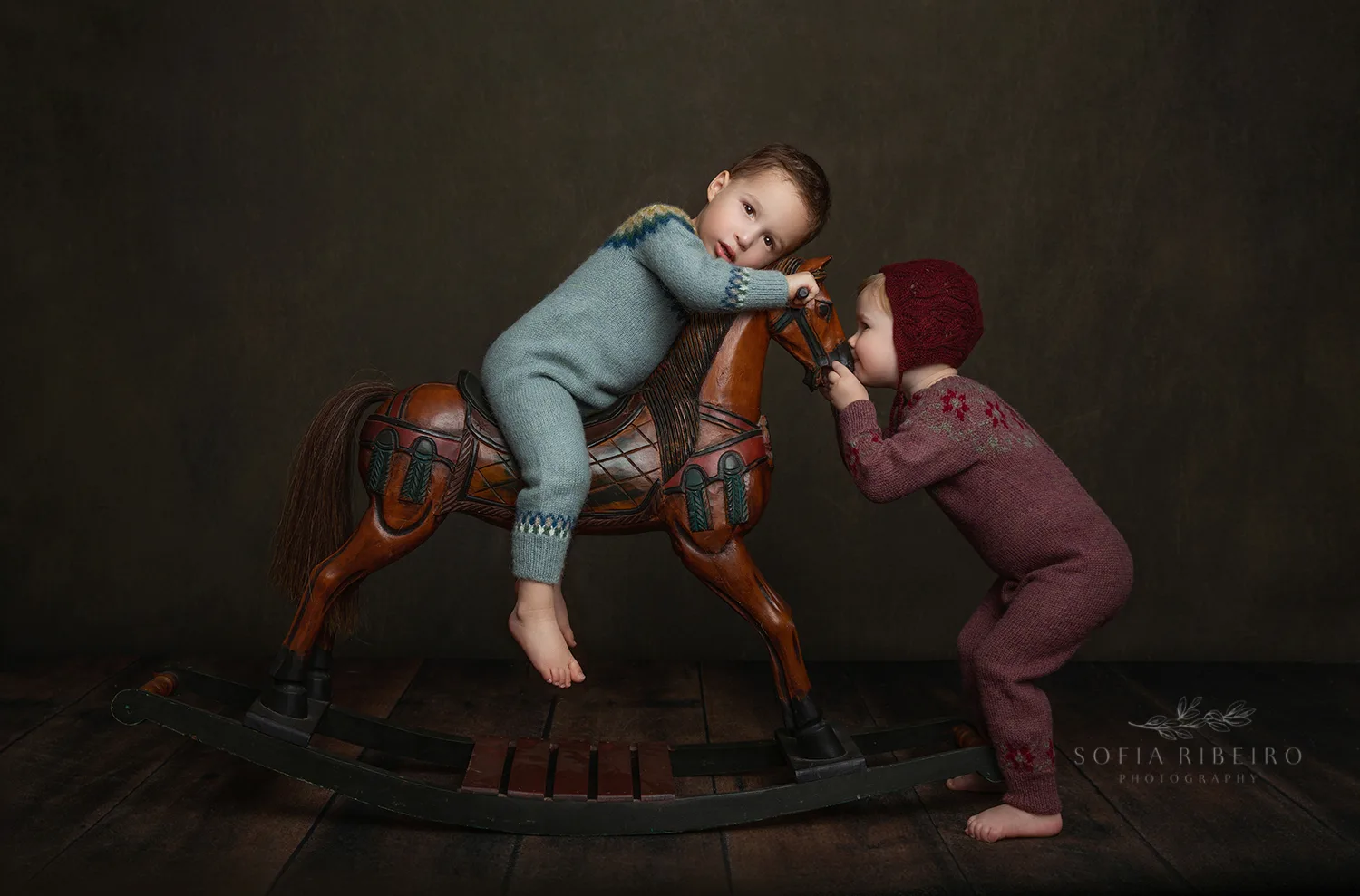 siblings play with a vintage rocking horse while taking photos in a new jersey photographers studio