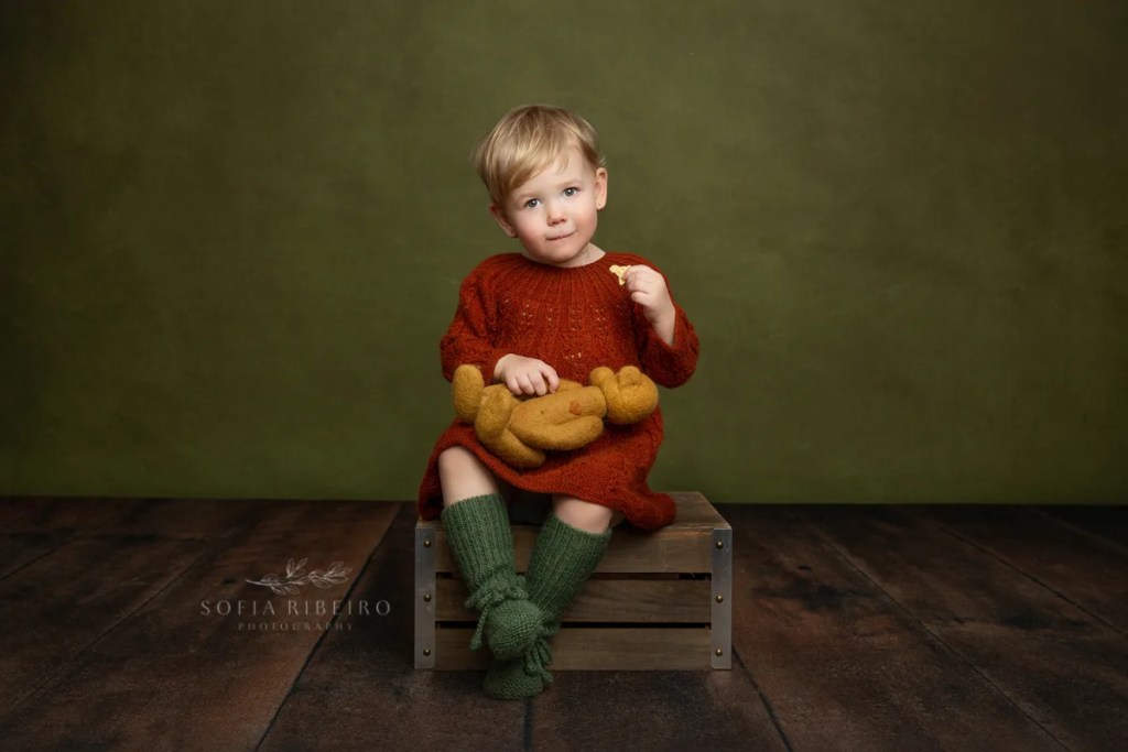 LITTLE GIRL WITH HAND KNIT OUTFIT AND TEDDY BEAR CELEBRATES HER SECOND BIRTHDAY AFTER TAKING PHOTOS WITH NJ CHILDRENS PHOTOGRAPHER IN STUDIO