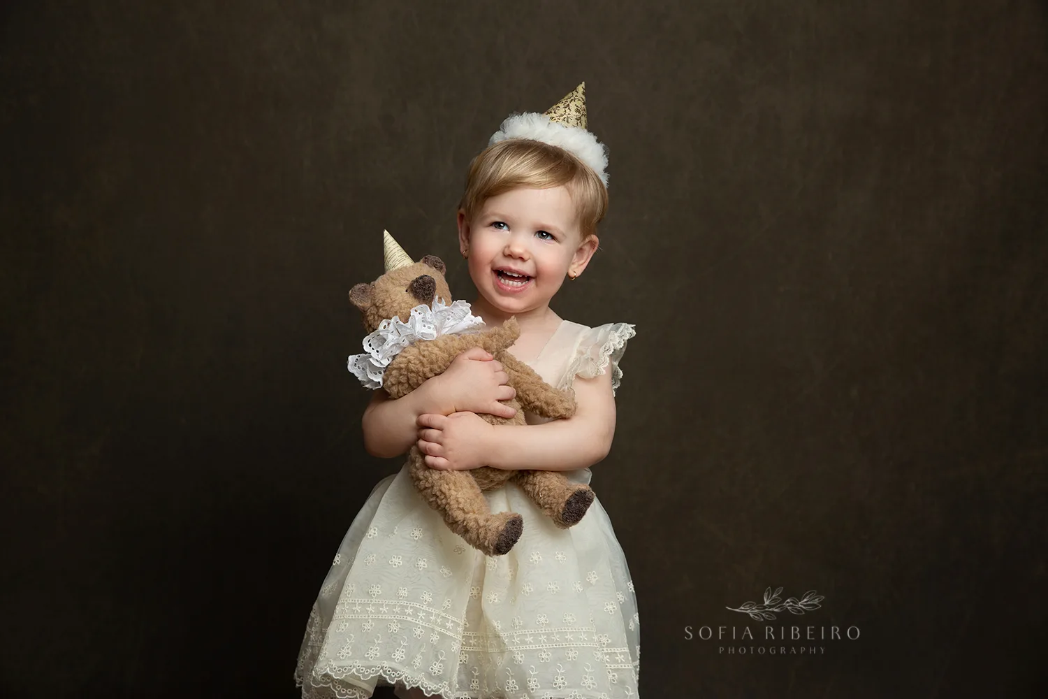 LITTLE GIRL WITH TEDDY AND BIRTHDAY HAT CELEBRATES HER SECOND BIRTHDAY AFTER TAKING PHOTOS WITH NJ CHILDRENS PHOTOGRAPHER IN STUDIO