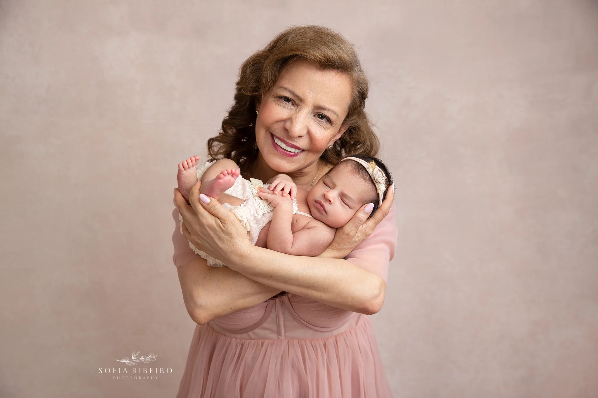 grandma holds her newborn baby granddaughter during a posed photo for portraits in nj