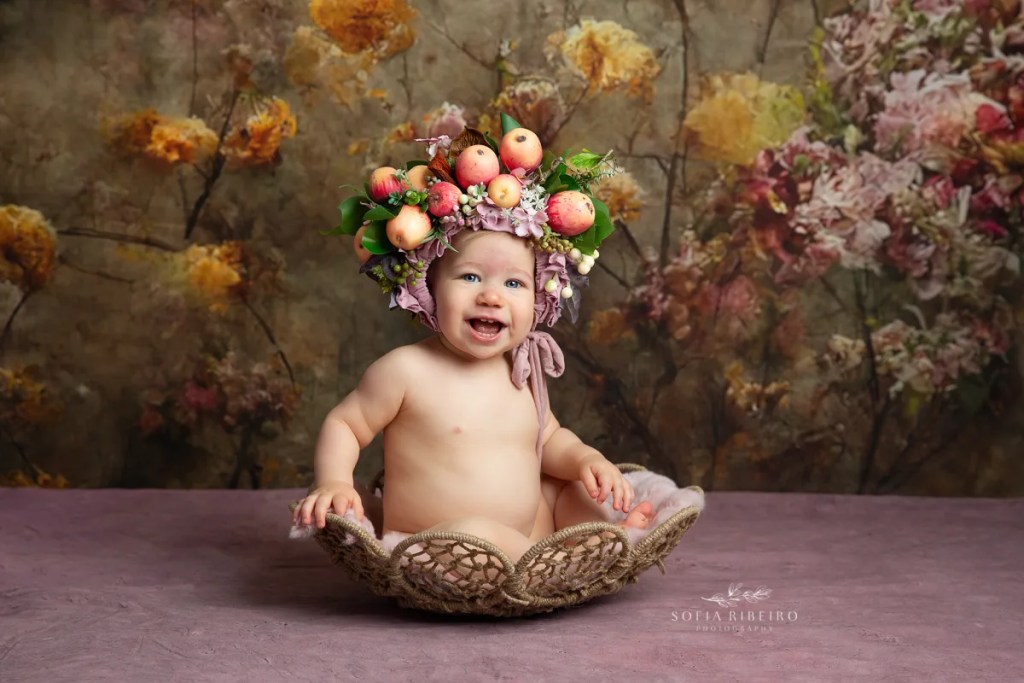 baby in bowl with fruit headpiece and florals