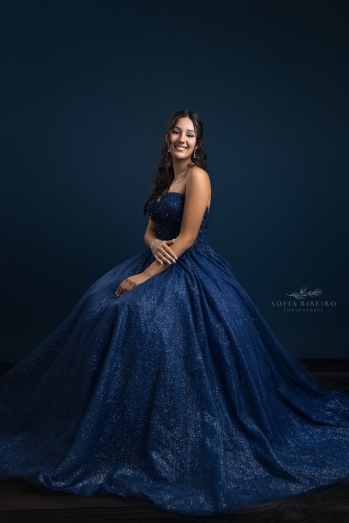 teen takes a formal seated portrait in navy blue gown at a nj childrens photography studio