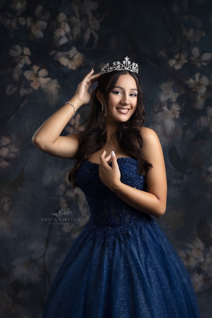 teen wears a crown and celebrates her sweet sixteen in a navy blue gown after taking portraits with a new jersey childrens photographer