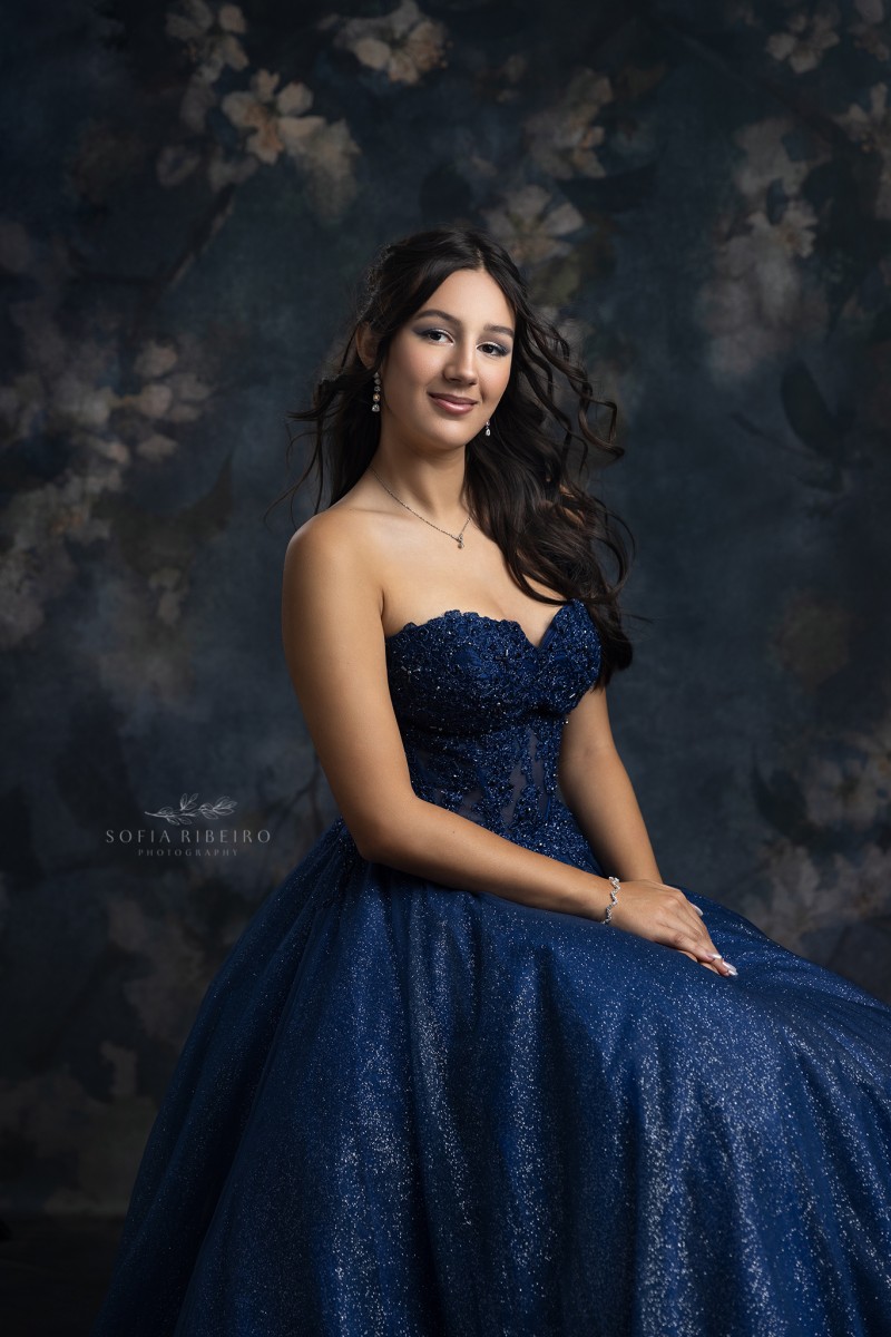 teen takes a formal seated portrait in navy blue gown at a nj childrens photography studio