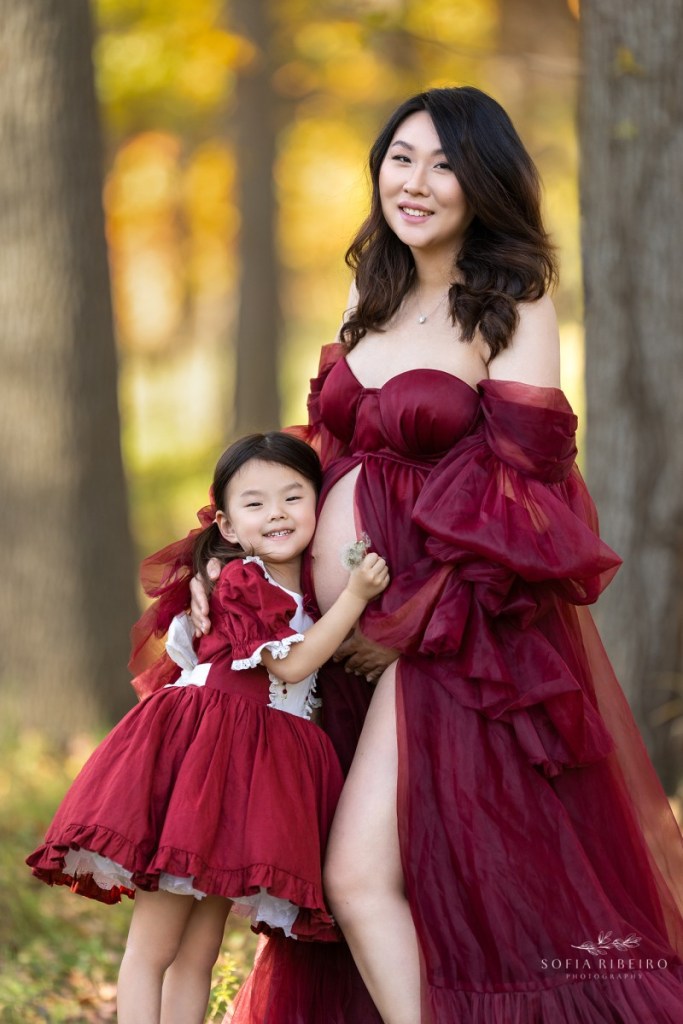 maternity session with mom and daughter in red dress in a local park in new jersey in the fall