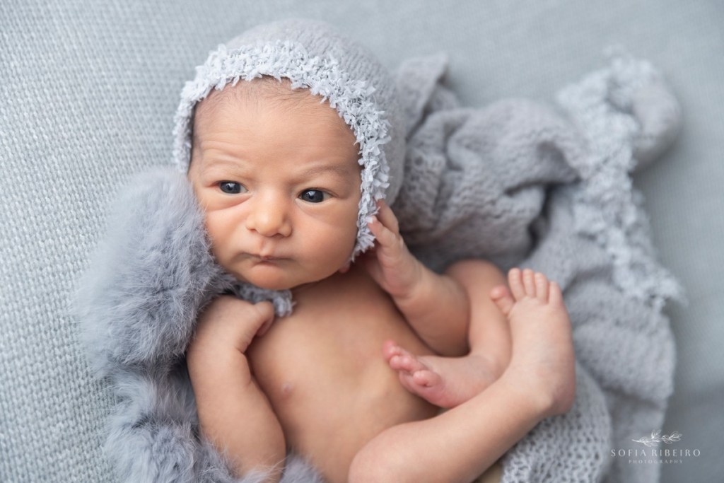 grey newborn session, baby awake in grey wrap and bonnet