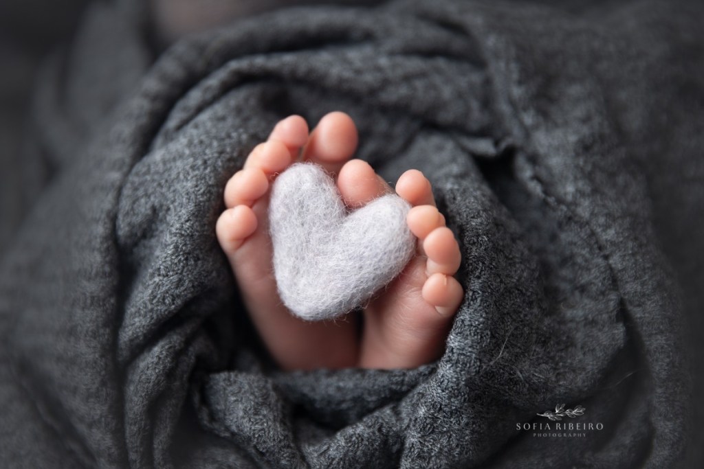 grey newborn session, baby toes wrapped around heart