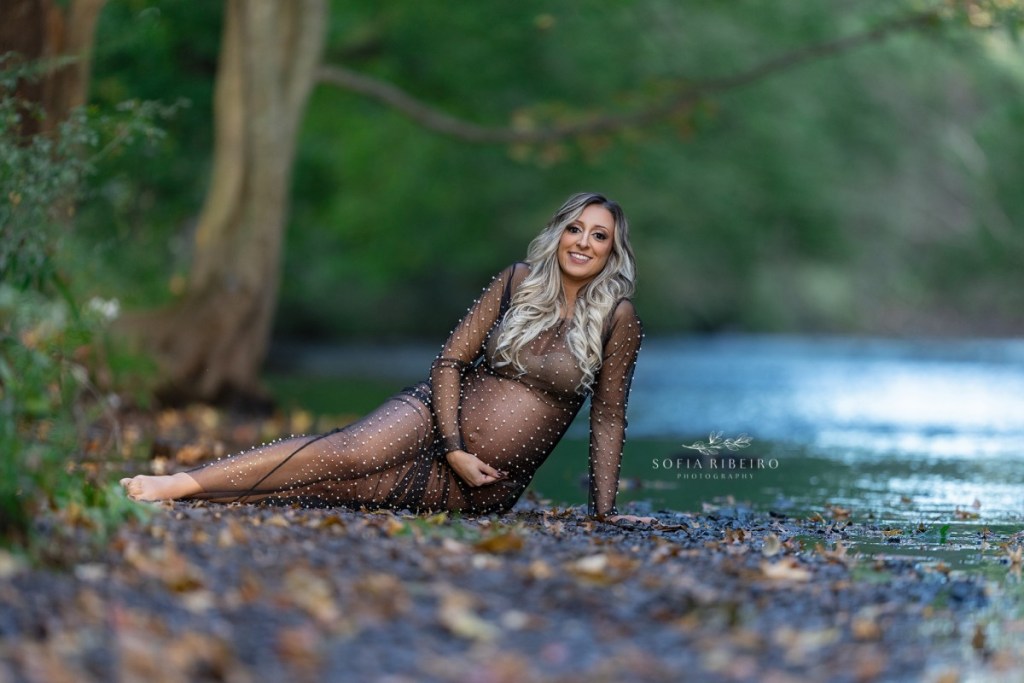 nj outdoor family maternity session, mom laying down near water in black dress