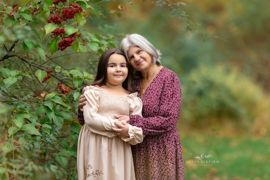grandmother poses with granddaughter during a family session