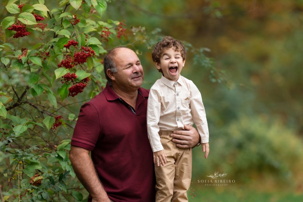 grandfather poses with grandson during a family session