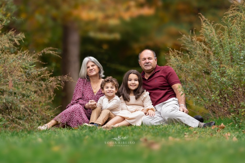 grandparents pose together with grandchildren in the grass