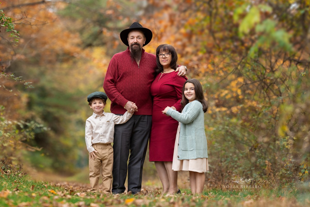 grandparents pose together with grandchildren in the grass