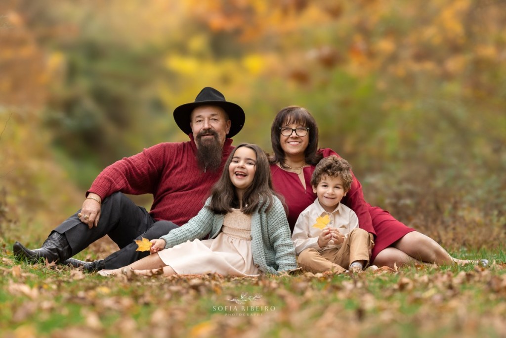 grandparents pose together with grandchildren in the grass