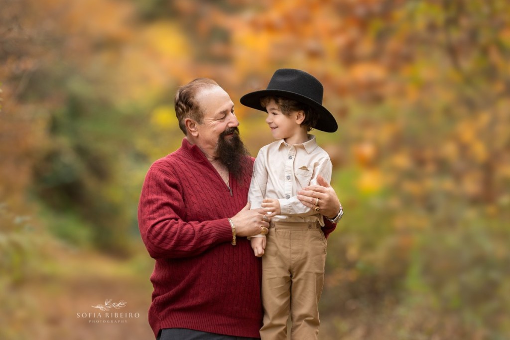 grandfather poses with grandson in a cowboy hat