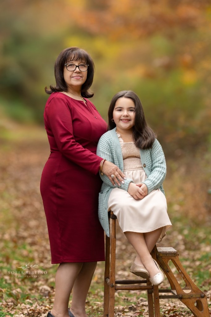 grandmother poses with granddaughter during a family session