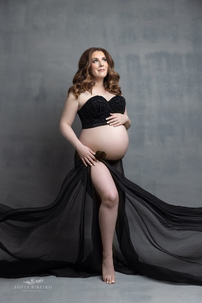 pregnant mom poses in a a black dress during a session with an nj maternity photographer