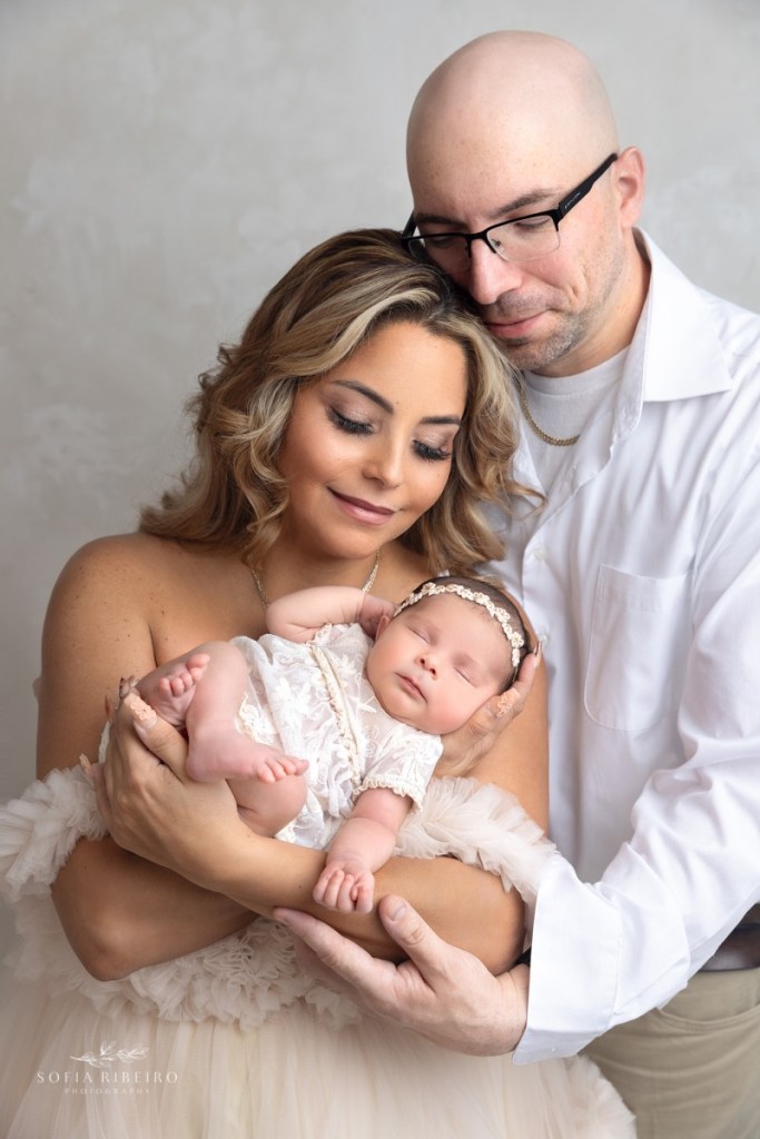 mom dad and baby snuggle together during a nj newborn photography session