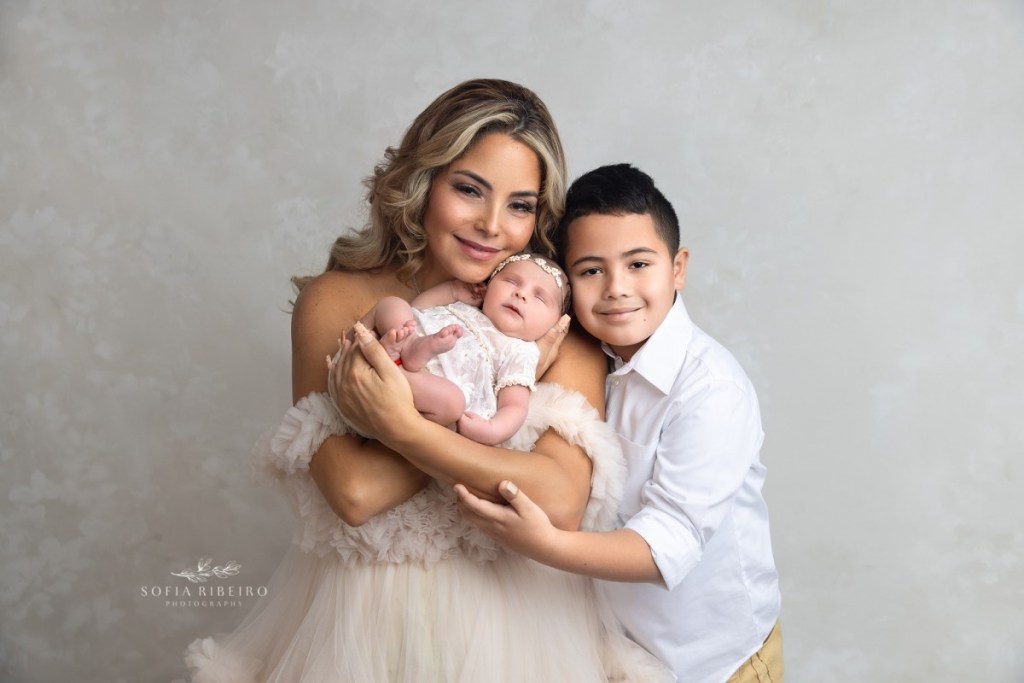 mom and big brother snuggle together during a nj newborn photography session
