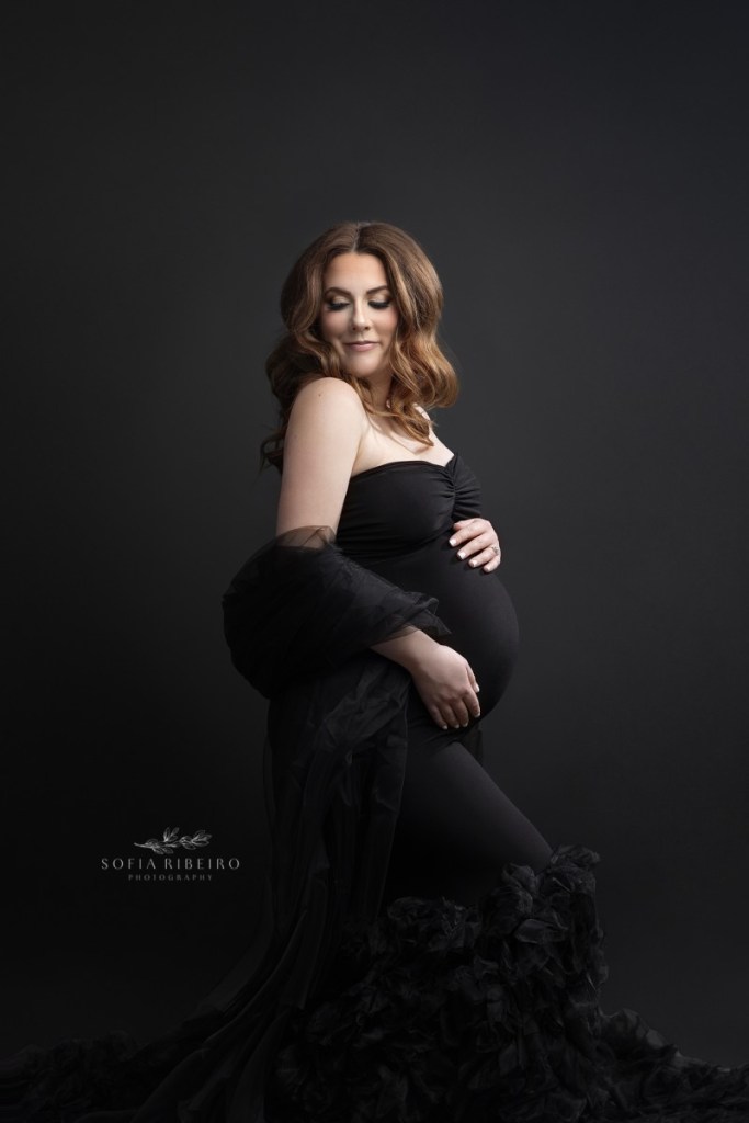 pregnant mom poses in a a black dress during a session with an nj maternity photographer