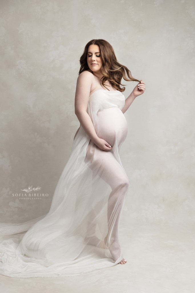 pregnant mom poses in a a white fabric during a session with a south plainfield nj maternity photographer