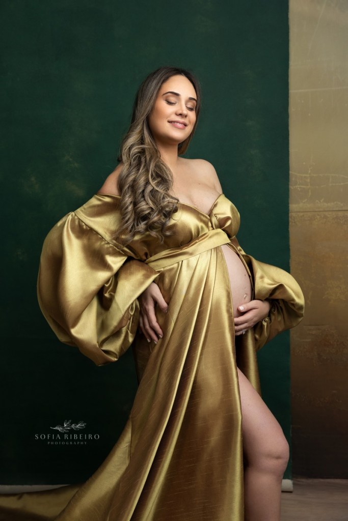 mom poses in a golden dress during a maternity photos