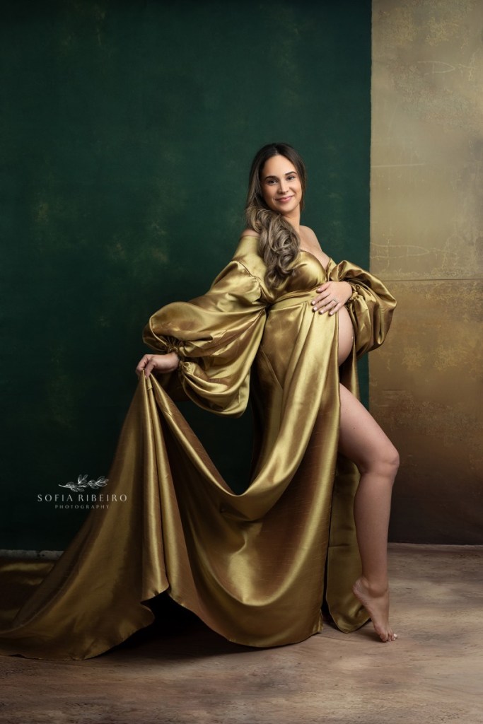 mom poses in a golden dress during a studio maternity session in nj