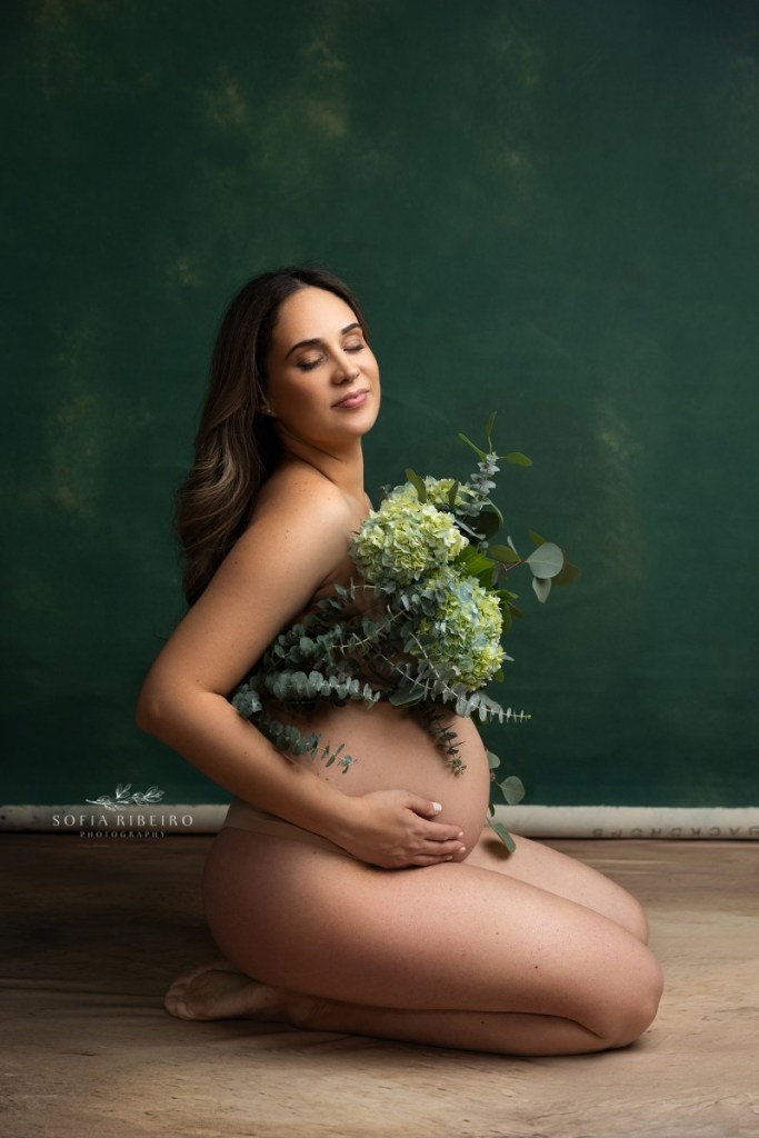 mom holds a bouquet of hydrangeas while relaxing into a pose during a maternity session in nj