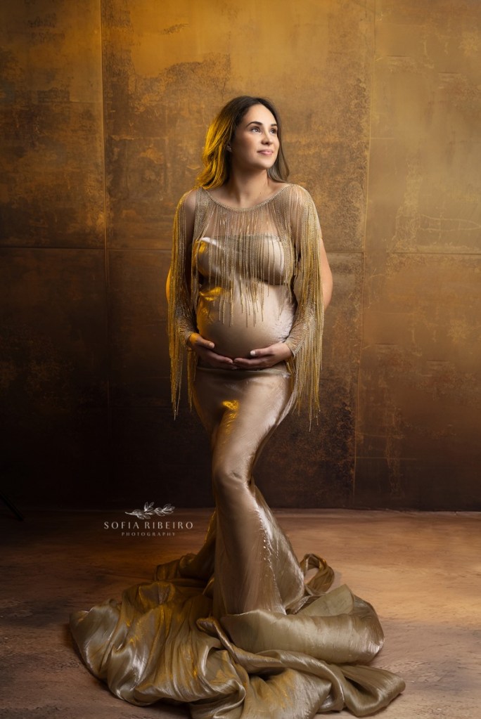 mom poses in a golden dress during a studio maternity session in nj