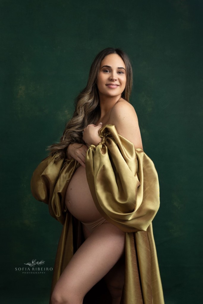 mom poses in a golden dress during a studio maternity session in nj