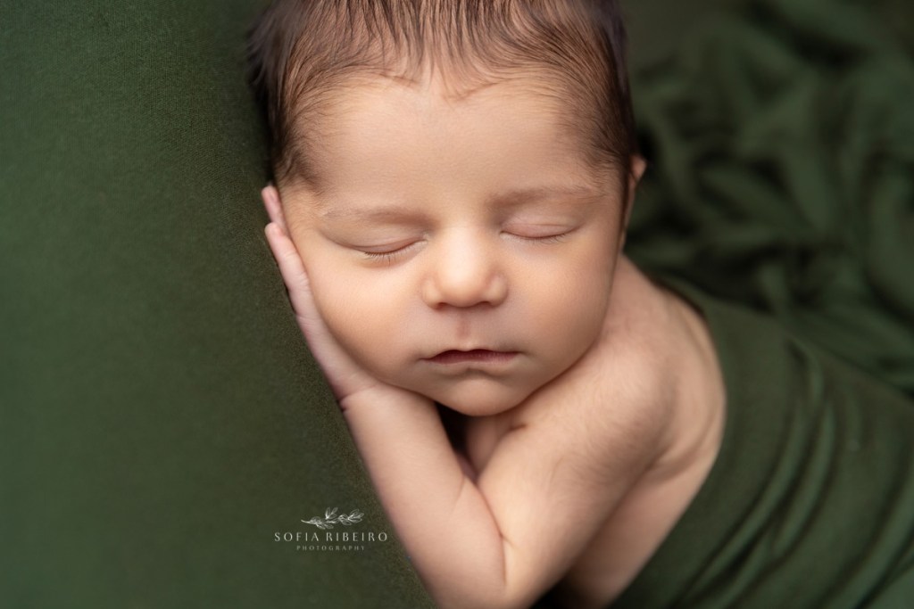 baby sleeps wrapped in a green wrap
