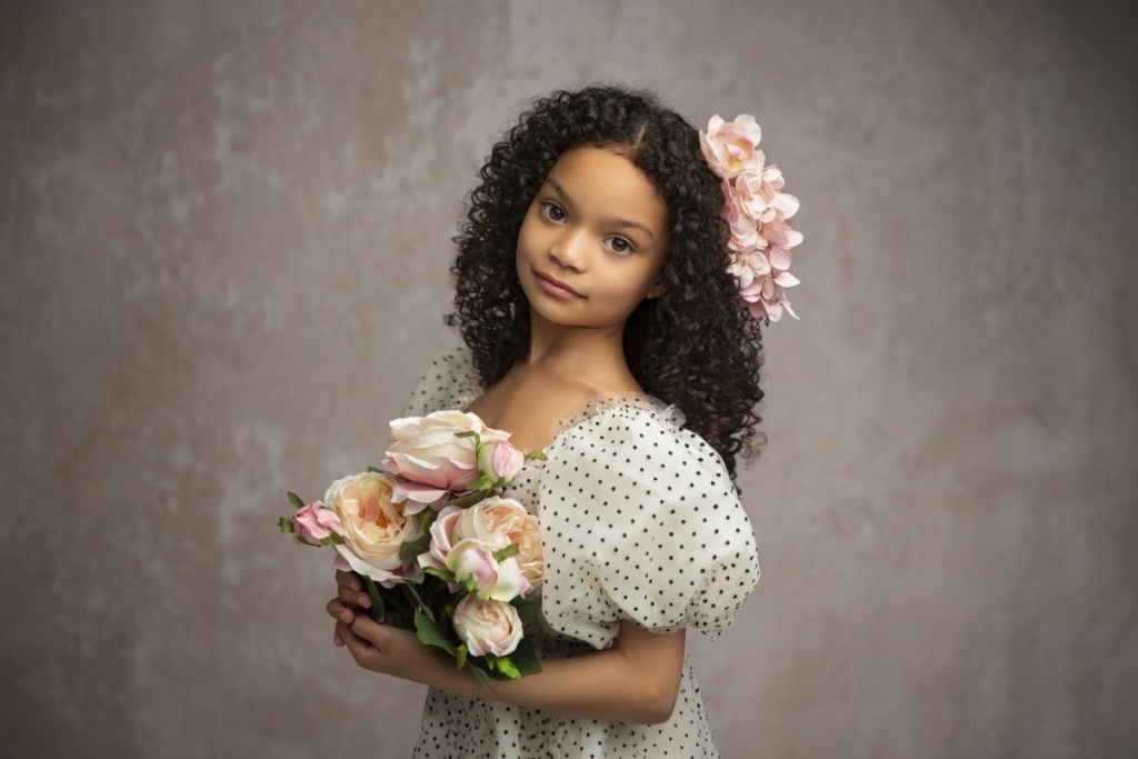 classic portrait of a young girl in a polka dot dress holding flowers during a nj studio portrait session