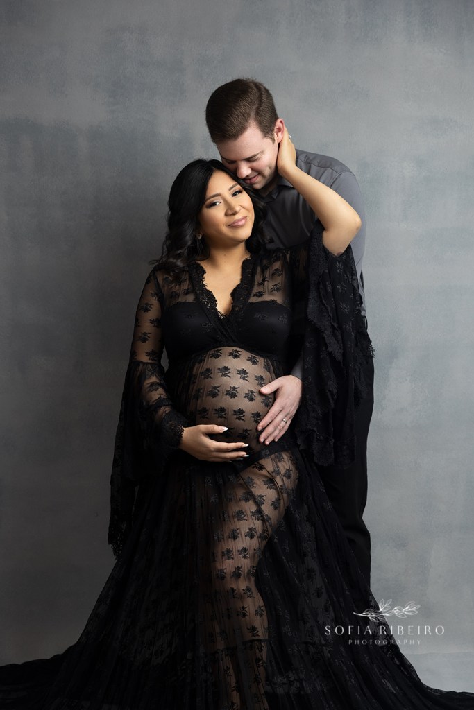mom holds dad's face while he hugs her belly during a maternity portrait session in new jersey