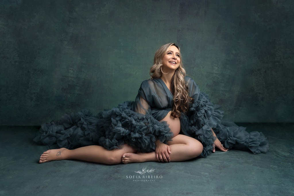 mom poses in a teal ruffled robe exposing her belly during a photo session with a clark nj maternity photographer