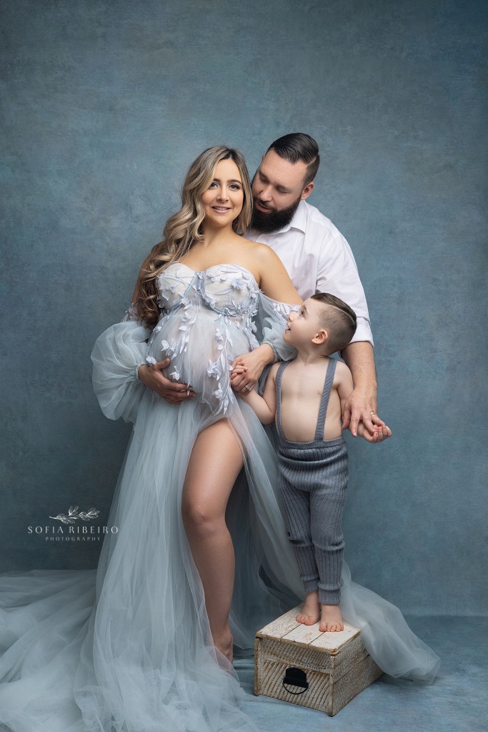 mom, dad, and their toddler son pose while smiling at the camera with a clark nj maternity photographer