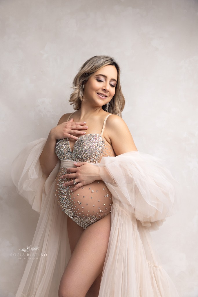 mom poses in a rhinestone bodysuit and robe during a maternity session in clark nj