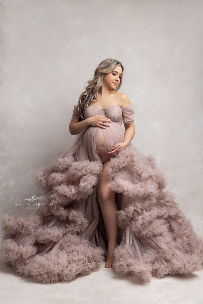 mom holds her belly in a fluffy maternity gown during a session in clark nj