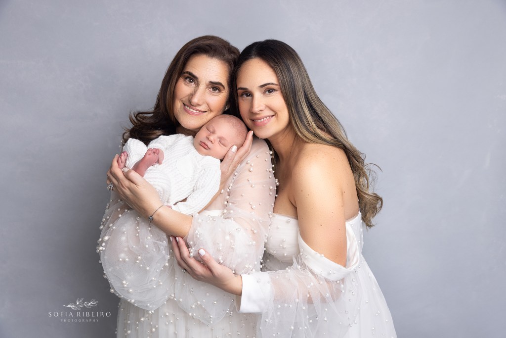 mom holds baby with grandma during his newborn photo session