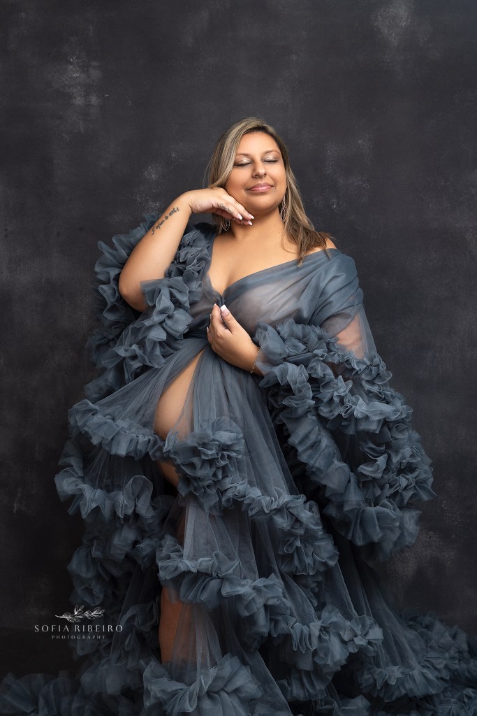 mom poses in a blue dress showcasing her belly during a photo session with a roselle park nj maternity photographer