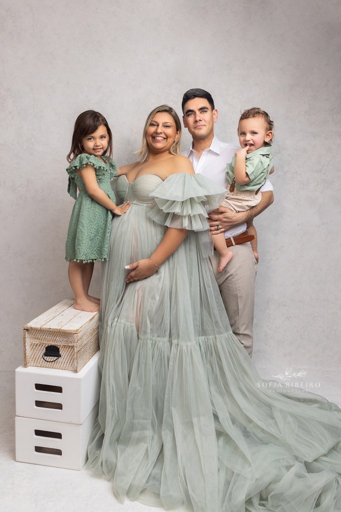 mom poses with her entire family in a green ruffled gown during her maternity session in roselle park nj