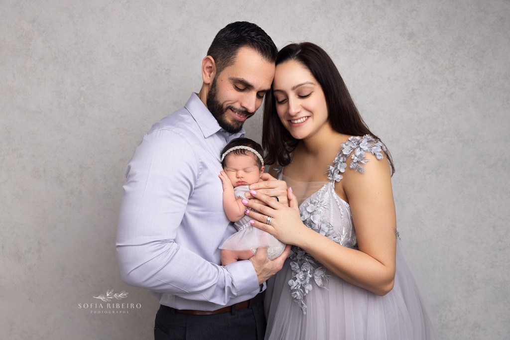 mom and dad pose with baby during a session with a colonia nj newborn photographer