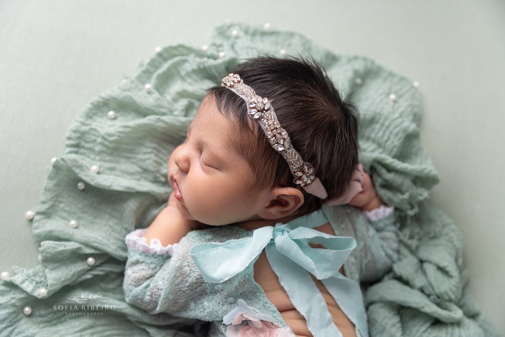 a newborn baby girl is photographed in a mint and pink outfit with a cranford nj newborn photographer