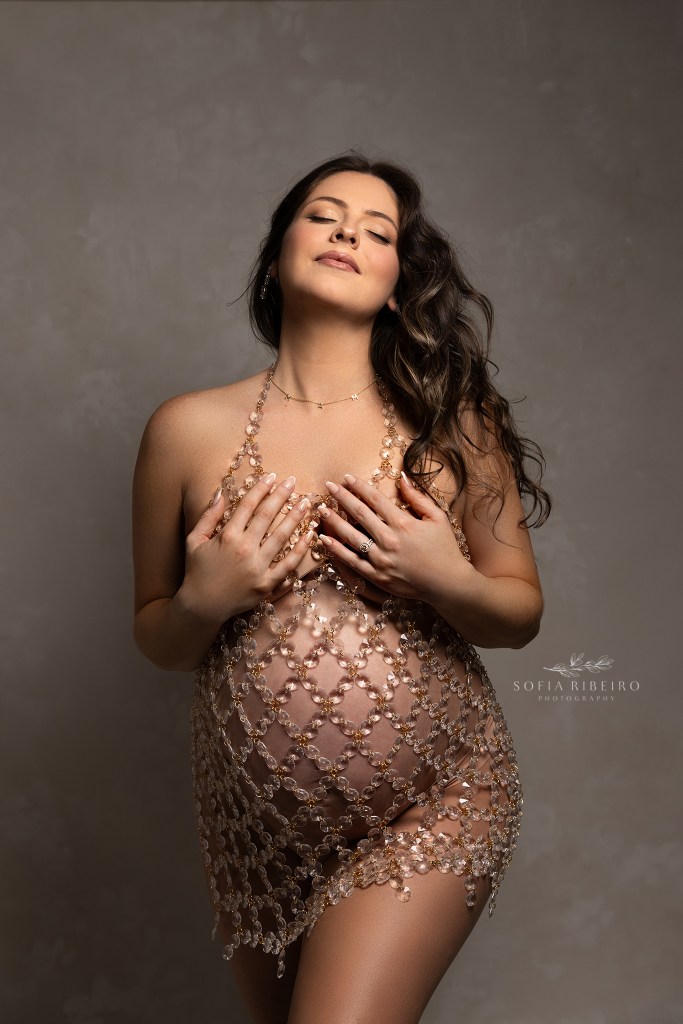 a photo of expectant mom to be in a crystal dress with hair blowing back with a dover nj maternity photographer