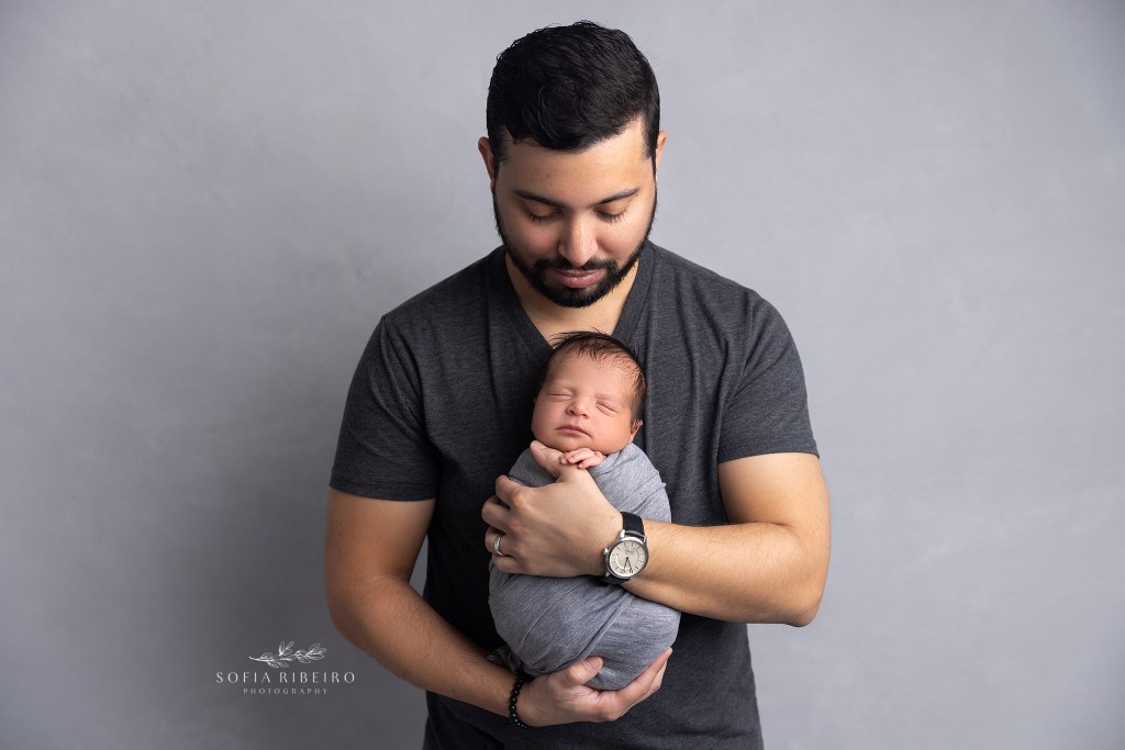 a dad lovingly holds his newborn son during a photo session in garwood nj