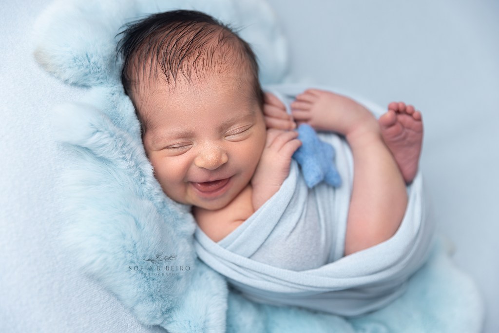 garwood nj newborn photographer captures a smiling newborn wrapped in blue