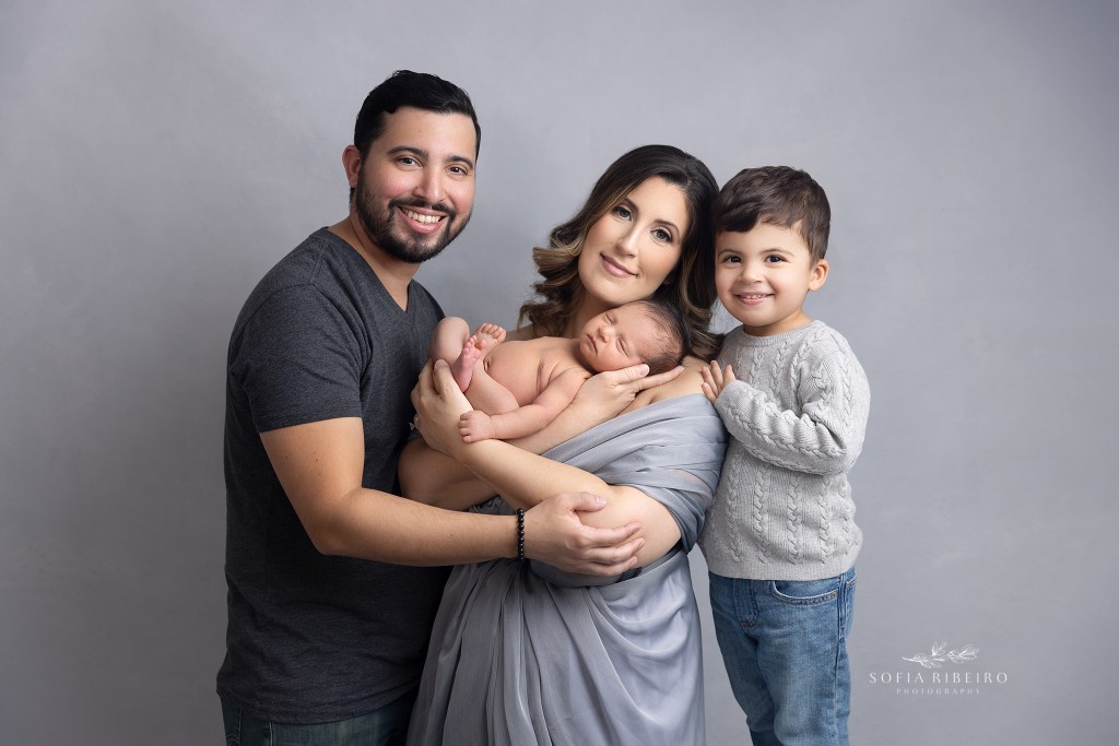 a new family poses together with their baby boys during a newborn photo session in garwood nj