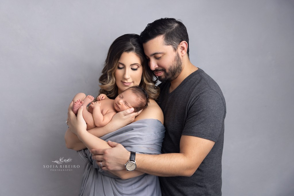 mom and dad lovingly cradle baby boy together