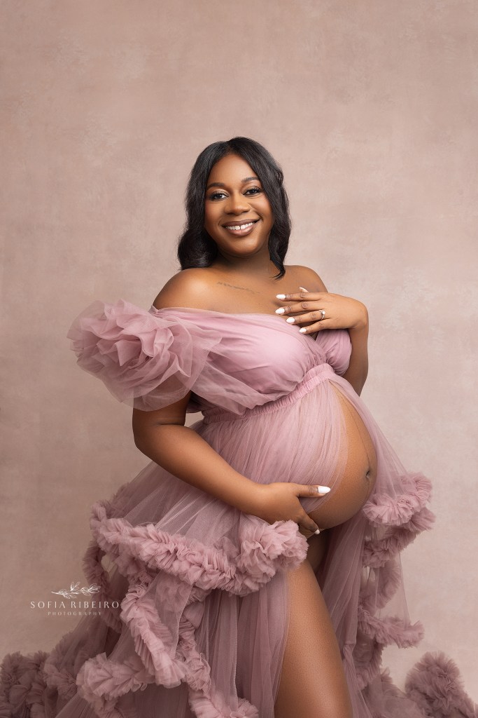 mom delicately holds a pose, dressed in a pink tulle gown during a maternity session with an lgbtq maternity photographer in nj