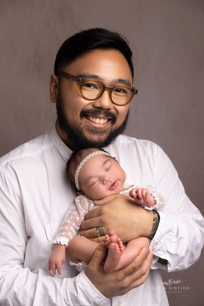 dad snuggles his new little girl and smiles during a newborn session in randolph nj